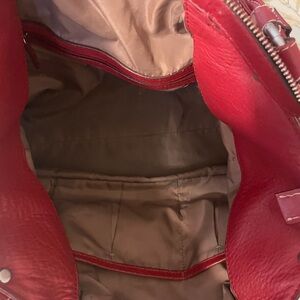 Red leather hand bag.  Good shape. Small pen mark noted in photo.  No tears